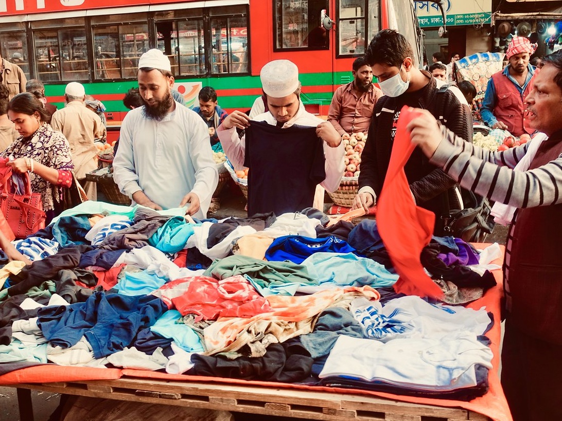 En prydlig hög med nya, vikta märkeskläder för barn i olika färger.